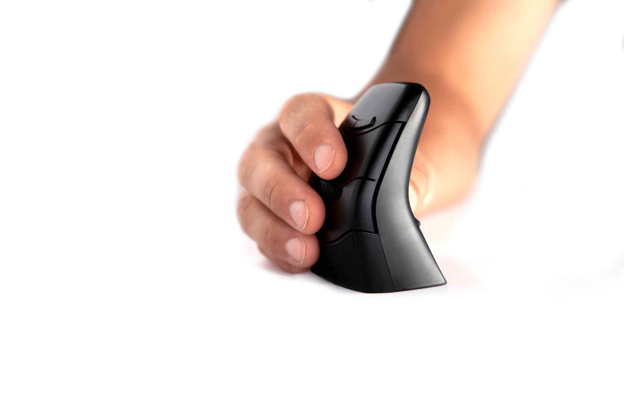 Wireless compact ergonomic ambidextrous mouse in sleek black design, featuring a curved shape for comfort and easy grip, held by a hand against a white background.