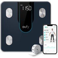 Black square Eufy electronic scale with digital display, four silver sensors, smartphone app, and measuring tape.