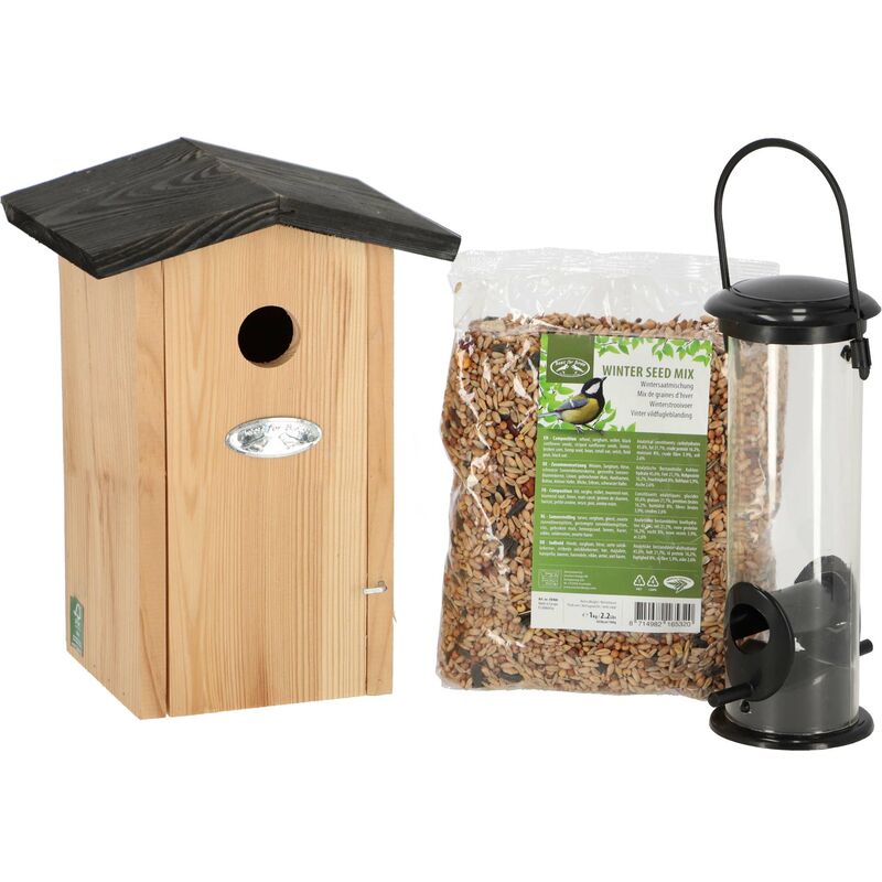 Wooden birdhouse with a slanted black roof, a circular entrance hole, a bag of winter seed mix, and a clear plastic seed feeder with a black base.
