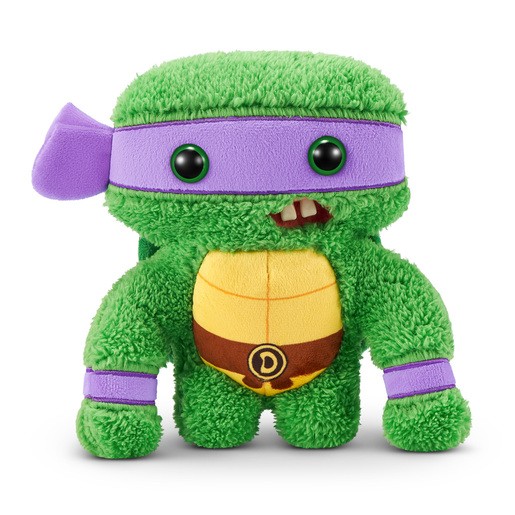 Green soft toy resembling Donatello from TMNT, featuring a purple mask, yellow shell, and quirky smile with visible teeth, made of plush material.