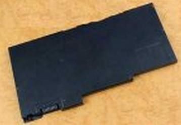 Black rectangular laptop battery with a smooth plastic surface, featuring a connector on one side and a sleek, minimalist design.