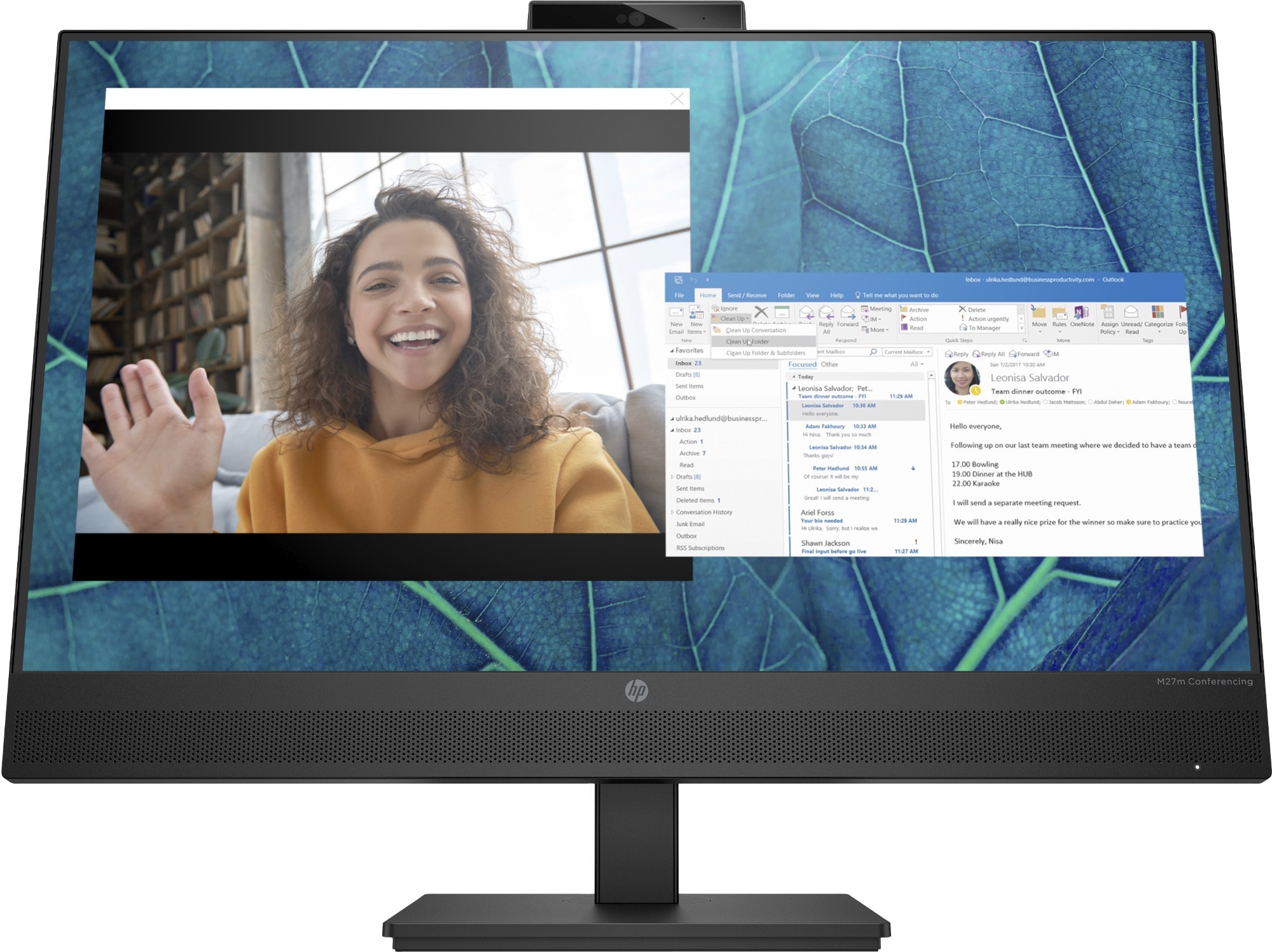 HP M27m Conferencing Monitor features a sleek black design with a built-in webcam, displaying a video call and a document on its vibrant screen, set against a textured blue background.