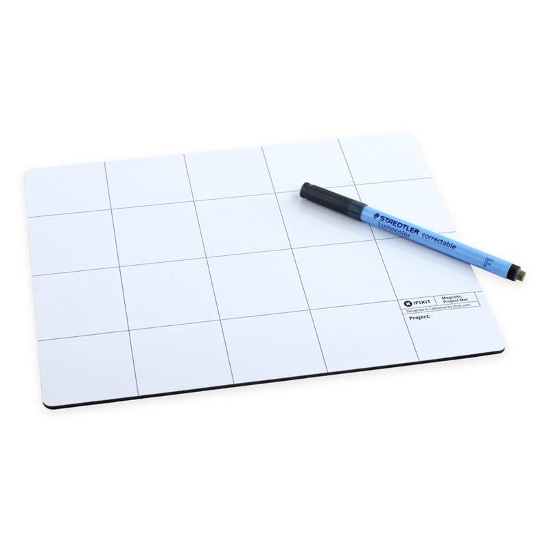 White magnetic project mat with a grid layout, featuring labeled sections for organization, accompanied by a blue dry-erase marker for notes.