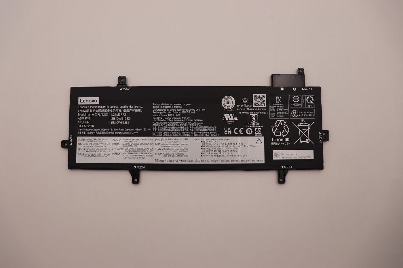 Black Lenovo lithium-ion battery with a capacity of 51.5Wh, featuring labels, barcodes, and safety information on a smooth surface.