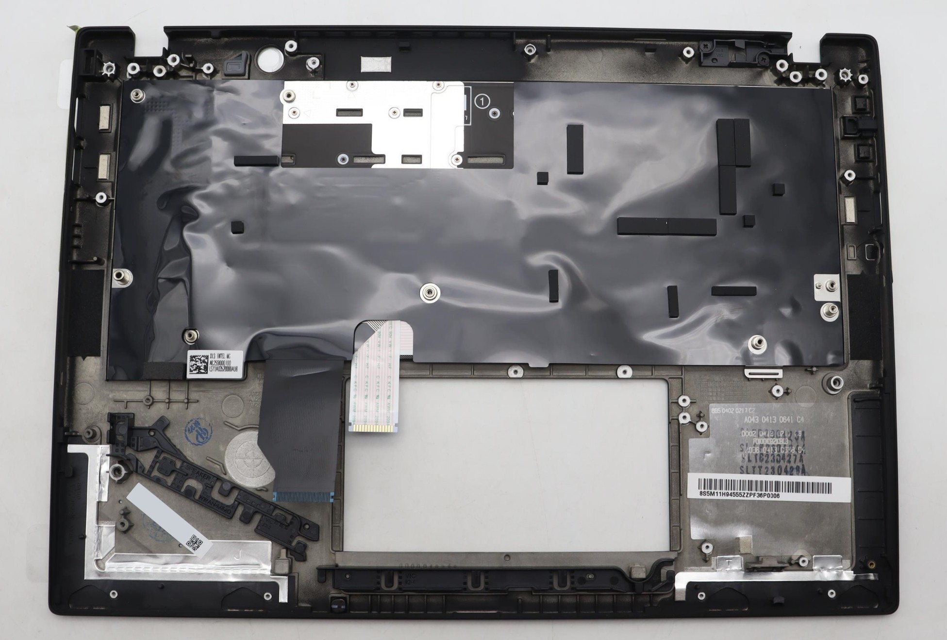Black plastic laptop cover with a glossy finish, featuring a keyboard area cutout, various mounting points, and a protective film over the internal components.