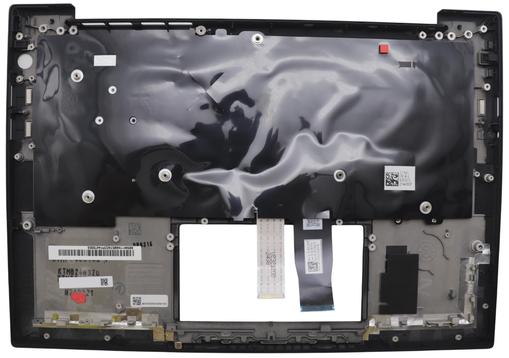 Black plastic laptop cover with a glossy finish, featuring various mounting points, connectors, and a rectangular cutout for the keyboard.