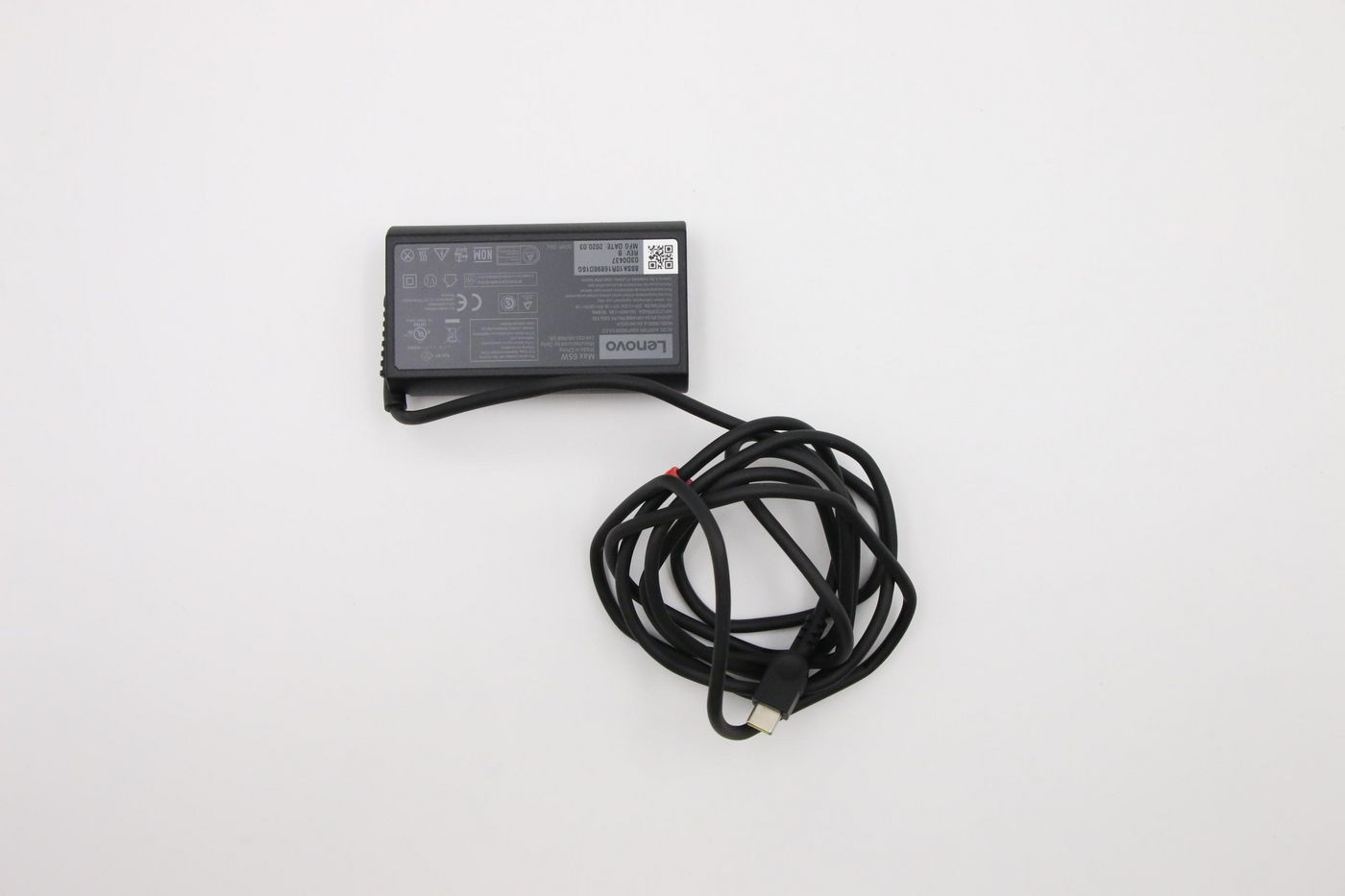 Lenovo 65W notebook power adapter in black with a textured surface, featuring a coiled cable and various technical labels on the back.