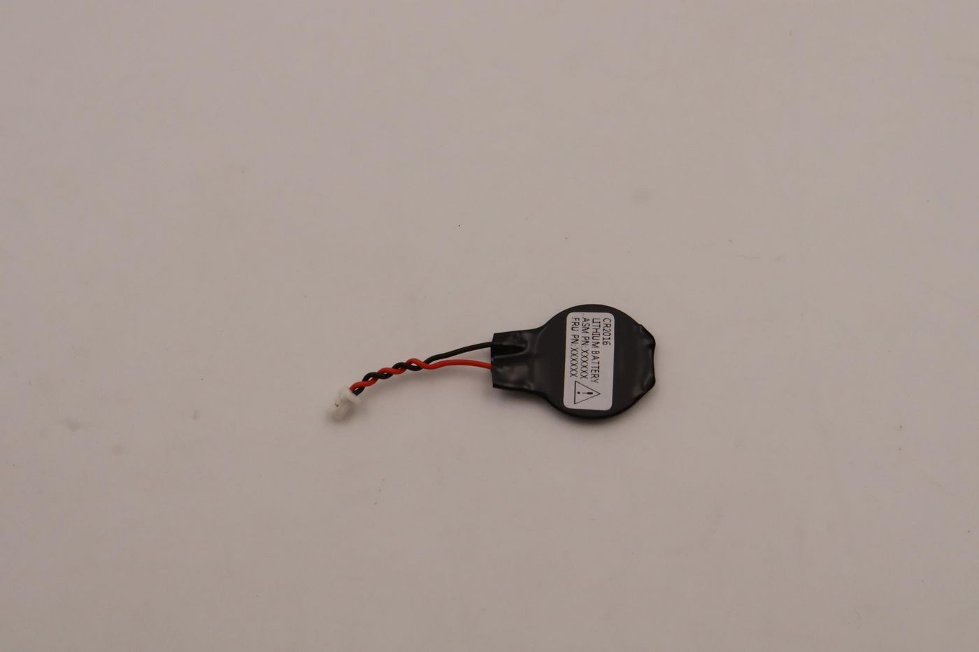 Black Lenovo CR2016 CMOS battery with a small connector wire, featuring a white label with safety information and a warning symbol, measuring approximately 30mm in diameter.