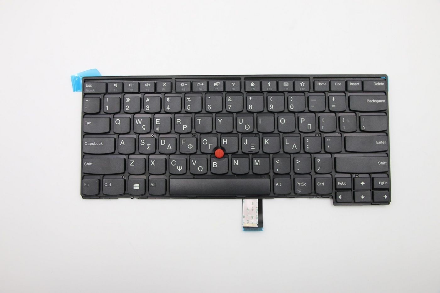 Black Lenovo keyboard featuring Greek layout, with white letters and symbols, a red trackpoint in the center, and a blue adhesive strip on the top left corner.