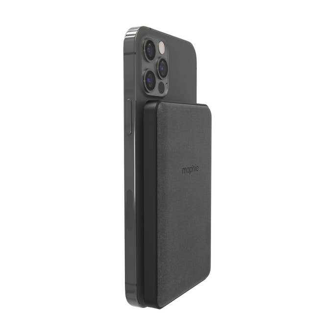 Black Mophie Snap+ Powerstation Mini 5k, featuring a sleek design, magnetically attaches to a smartphone, offering wireless charging capability.