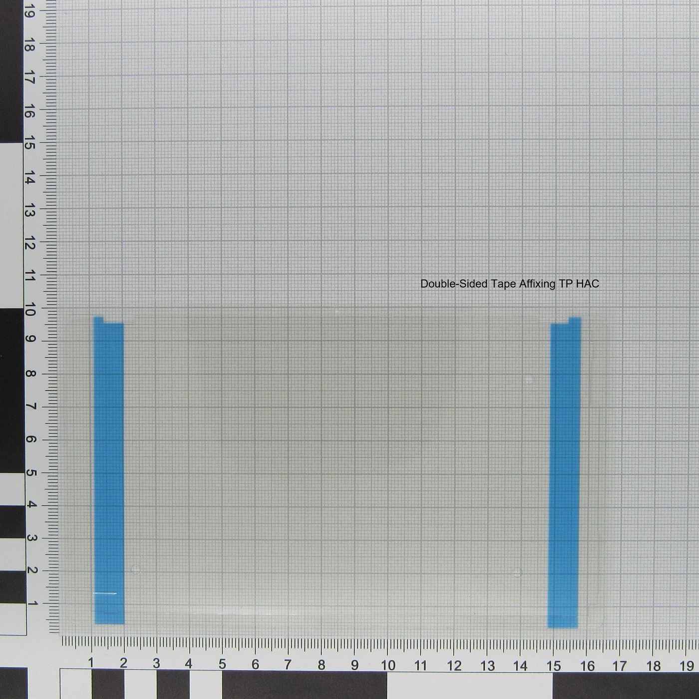 Clear plastic sheet with blue tape on both ends, featuring a grid background and measurement markings along the edges.