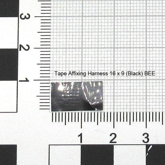 Black tape affixing harness labeled "Tape Affixing Harness 16 x 9 (Black) BEE," placed on a grid background with measurement markings.