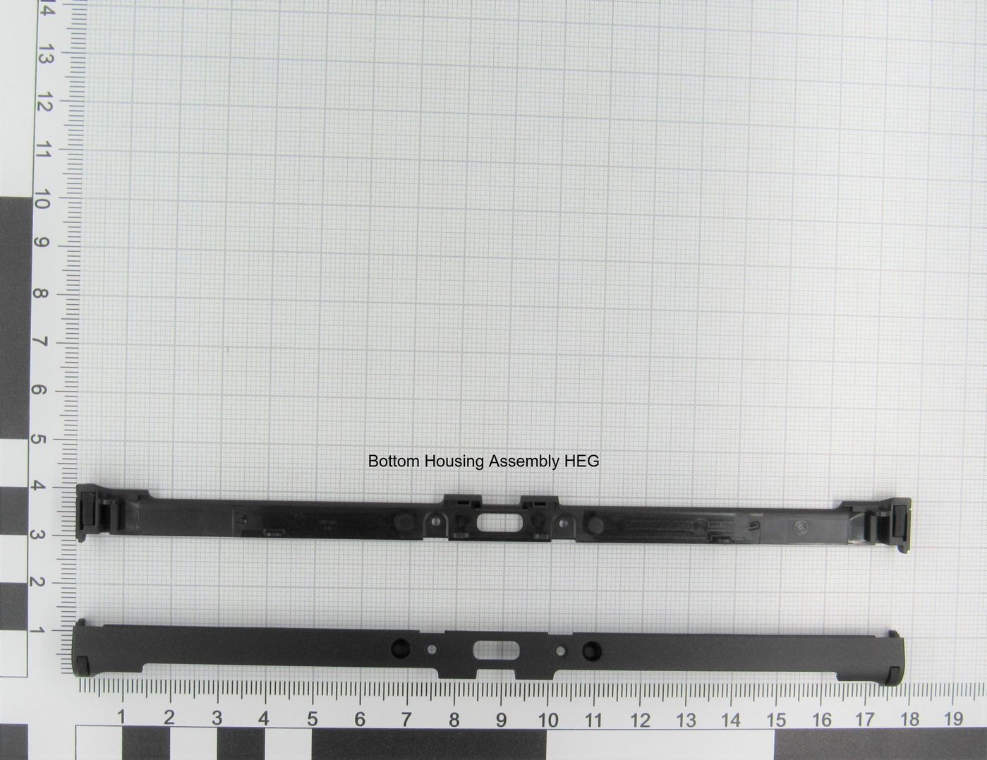 Black plastic bottom housing assembly for Nintendo device, featuring two parts with clips and a central opening, displayed on a grid background with measurement markings.