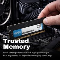 Origin Storage 32GB DDR5 SODIMM ECC RAM, black with label, held above a computer motherboard.