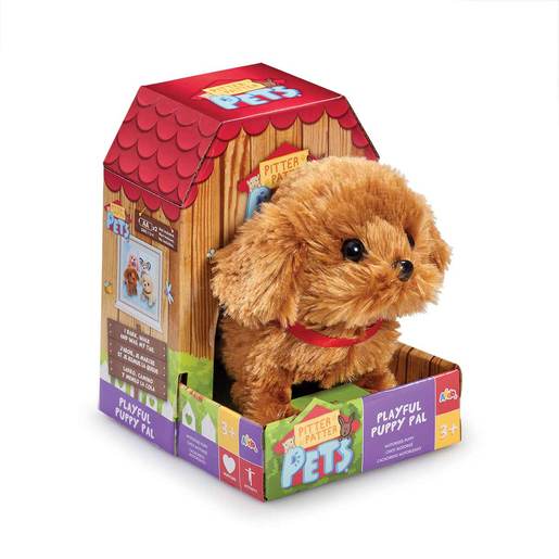 Fluffy, light brown electronic puppy with a red collar, sitting in a colorful cardboard doghouse packaging featuring playful graphics and a vibrant red roof.