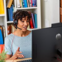 Black Poly Blackwire 5220 stereo headset with USB-C, 3.5mm plug, and USB-C/A adapter, worn by a person at a desk.