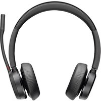 Black Poly Voyager 4320-M headset with cushioned ear cups, adjustable headband, boom mic, BT700 dongle, and charging stand.
