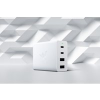 White Razer mobile device charger with three USB ports and embossed logo on a geometric patterned background.