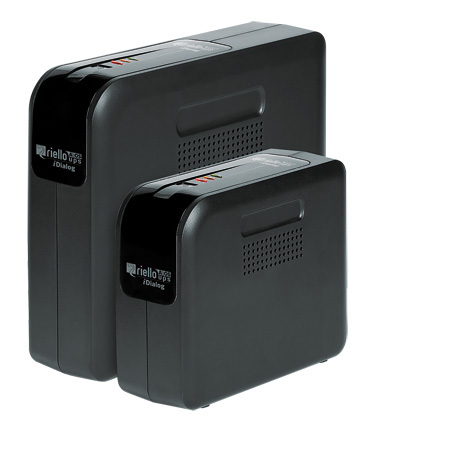 Black Riello IDialog Uninterruptible Power Supply (UPS) unit, featuring a compact design, with two sizes visible, indicator lights on top, and ventilation grilles on the sides.