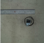 Samsung JC33-00028D solenoid spare part for printers/scanners, featuring a compact metal body with a wire attached, placed on a light-colored surface next to a ruler for size reference.