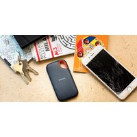 Black SanDisk Extreme Portable 2TB SSD with USB Type-C port, compact design, textured surface, next to keys and phone.