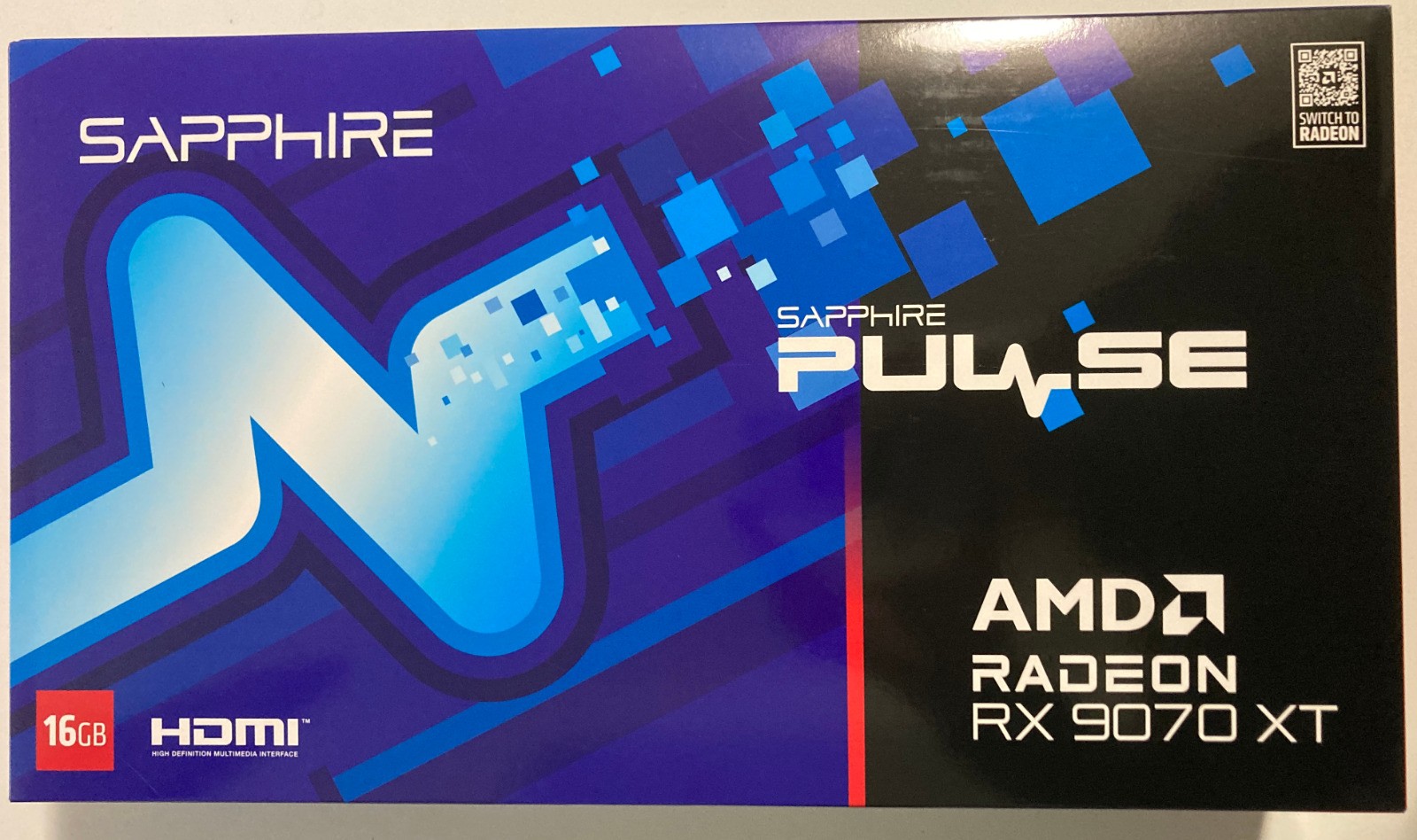 Sapphire Pulse Radeon RX 9070 XT graphics card box features a vibrant blue and purple design with the product name, 16GB label, and HDMI logo prominently displayed.