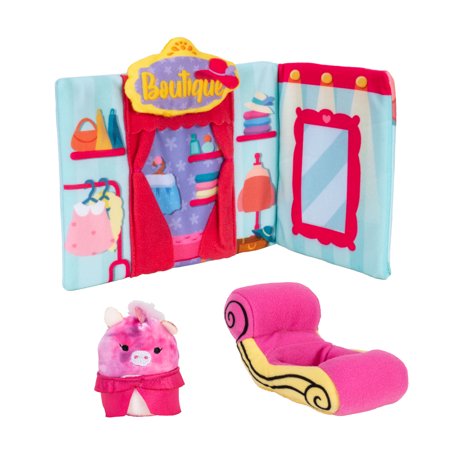 Lola's Boutique playset features a colorful foldable backdrop with clothing items, a pink plush couch, and a small pink and white plush character with a fluffy mane.
