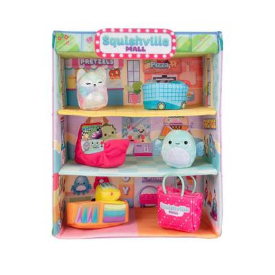 Colorful Squishville Mall Playset featuring three shelves with plush characters, a blue food truck, a pink shopping bag, and various accessories in a vibrant, cartoonish design.