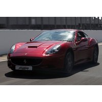 Red Ferrari F430 supercar on a racetrack, sleek design with aerodynamic curves and distinctive Ferrari logo.