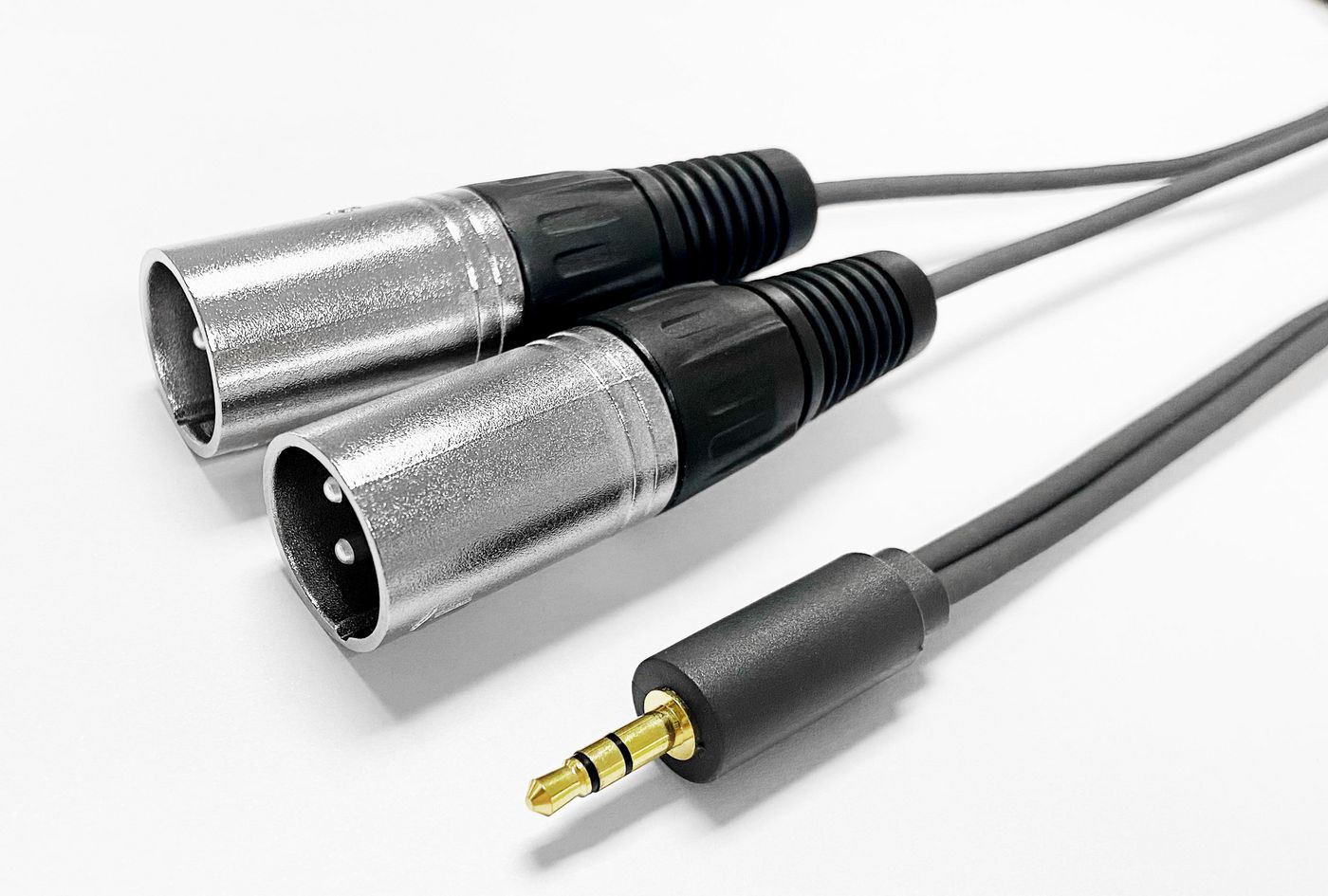 Black audio cable, 15 meters long, featuring two silver XLR connectors and a gold 3.5mm connector, designed for professional audio applications.