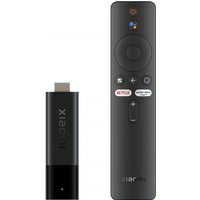 Black Xiaomi TV Stick 4K with HDMI connector and remote control featuring circular navigation pad and dedicated buttons.