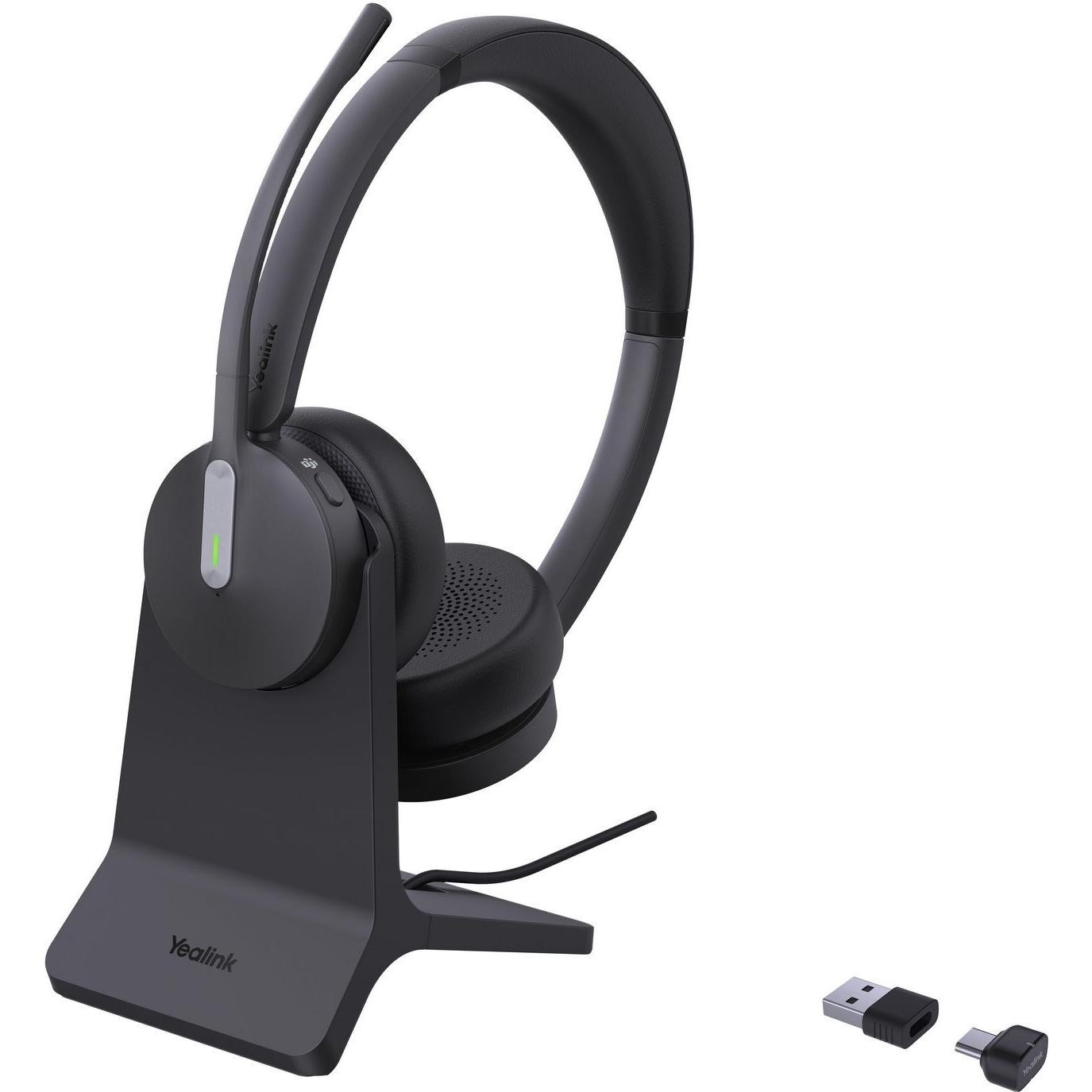 Black over-ear headset with a flexible microphone boom, soft ear cushions, and a sleek charging dock; includes a USB dongle for wireless connectivity.