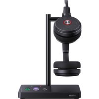 Black Yealink WH62 Dual Teams headset with cushioned ear cups on a sleek charging stand with control buttons.