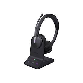 Yealink WH64 Dual UC Headset in black with a sleek design, featuring a flexible microphone boom, cushioned ear pads, and a charging base with indicator lights.