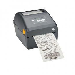 Compact black Zebra printer/scanner with a front paper output, featuring a control panel with three buttons and a small orange side button, printing a label with barcodes and text.