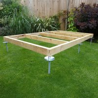 QuickJACK Adjustable Shed Base System with metal supports and wooden frame on grass, ideal for soft surfaces.