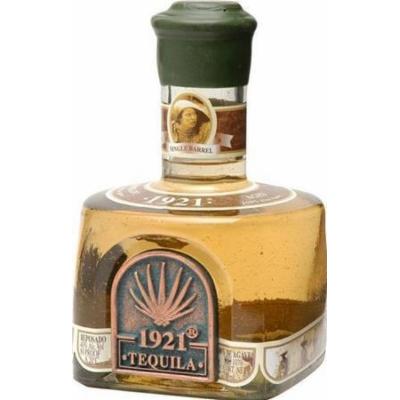 Clear glass bottle with a square base, filled with amber-colored tequila, featuring a green cap and a label with the text "1921 Tequila" and an agave plant emblem.