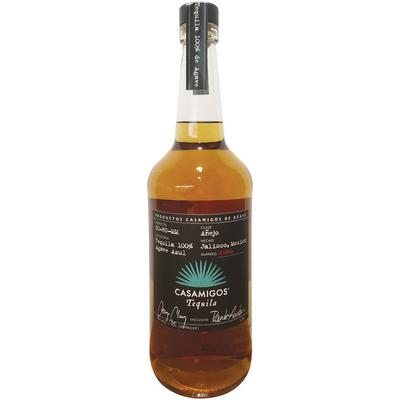 Casamigos añejo Tequila in a tall, clear glass bottle with a cork stopper, featuring a dark amber liquid and elegant black and white labeling.