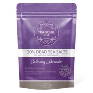 Purple packaging featuring the text "100% Dead Sea Salts" and "Calming Lavender," with a geometric design and a weight of 1KG, ideal for baths and hot tubs.