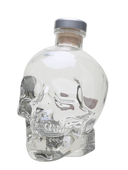 Clear glass vodka bottle shaped like a skull, featuring a silver cap and smooth surface, with intricate detailing on the facial features.