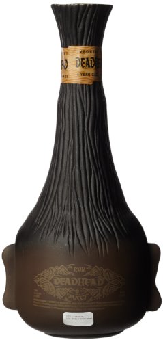 A dark, textured bottle shaped like a skull with a tapered neck, featuring a wooden-like finish and a label that reads "Deadhead 6 Year Old Cask Aged Rum."