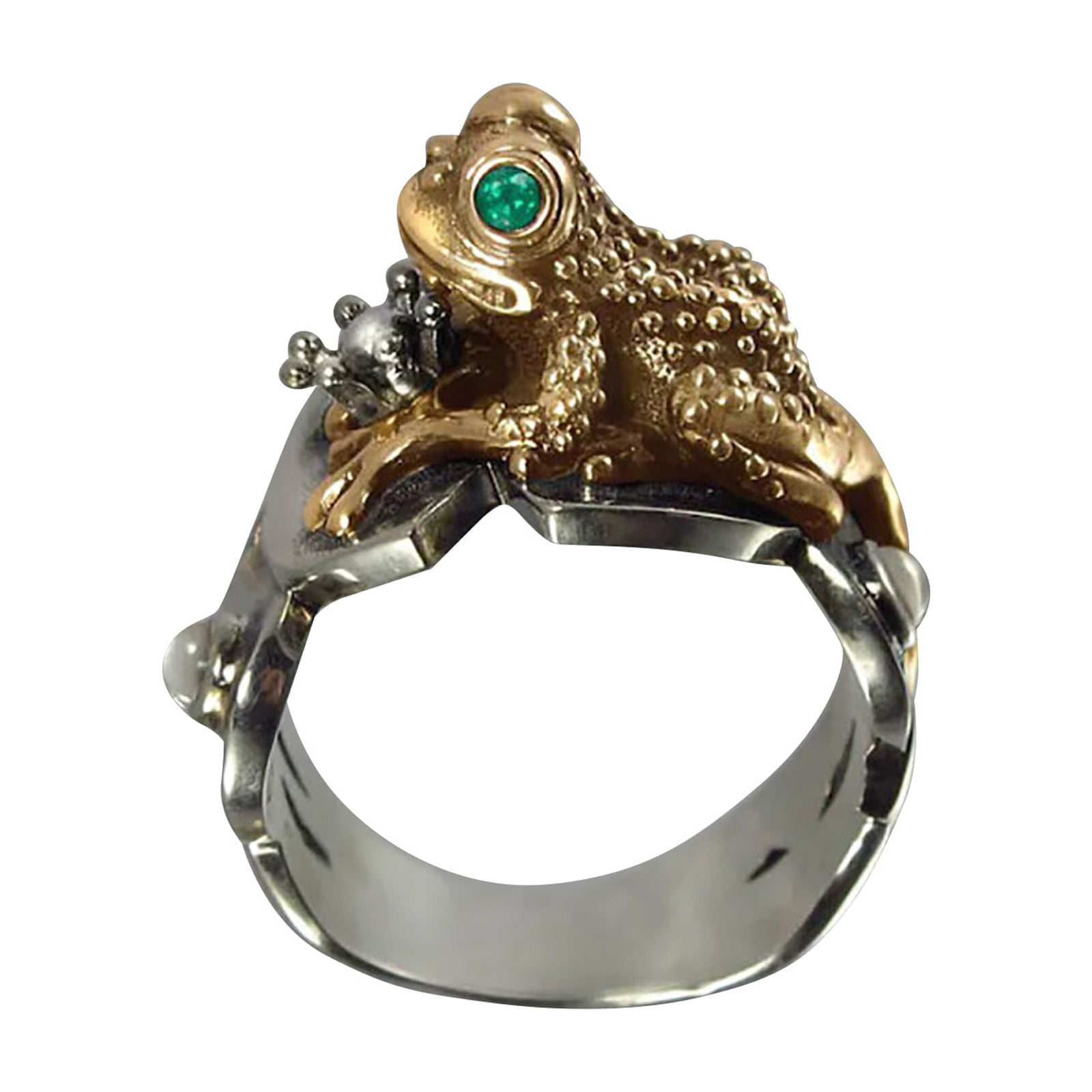 A silver ring featuring a detailed frog design with a gold finish and an emerald eye, holding a small silver crown in its mouth.