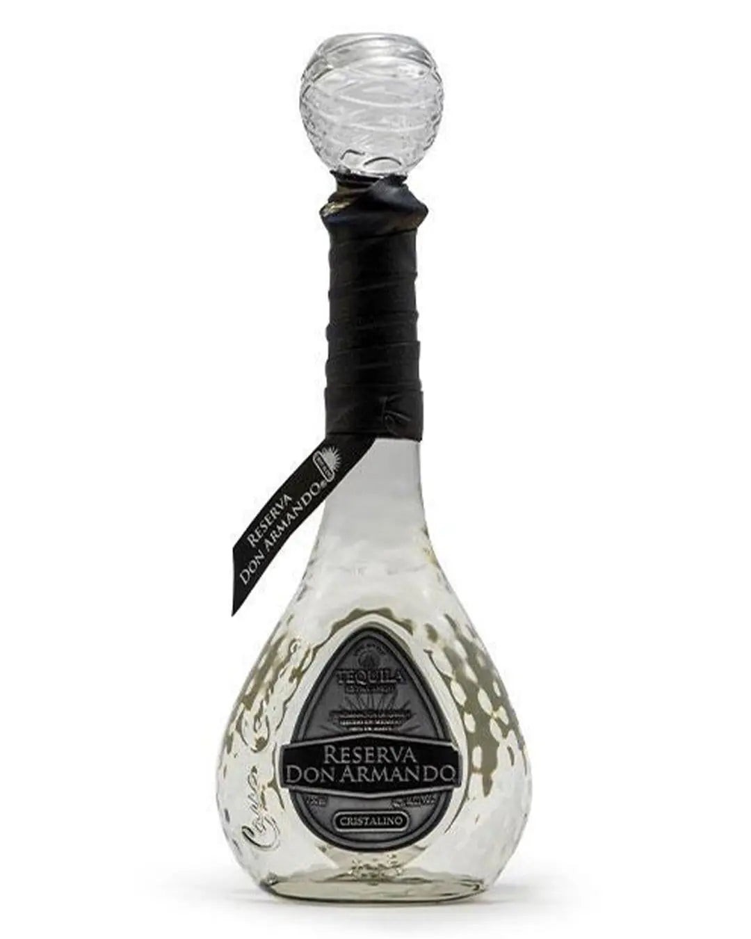 Clear, elegantly shaped glass bottle with a textured base, featuring a black label reading "Reserva Don Armando Cristalino" and a decorative round stopper.