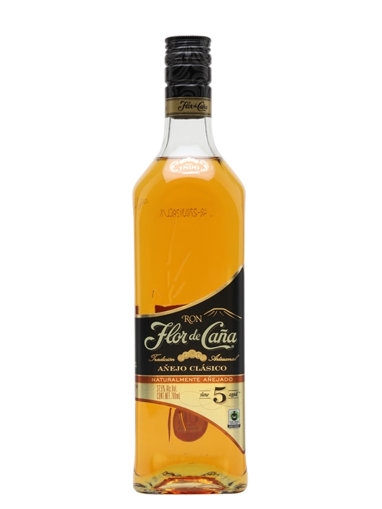 Clear glass bottle of Flor de Caña 5 Year Old Black Rum, featuring a golden amber liquid, a black and gold label, and a corked top, with a 70 cl capacity.