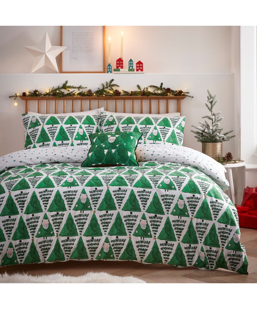 Reversible king duvet cover set featuring green Christmas trees and ornaments on one side, with a white polka dot pattern on the reverse, complemented by matching pillows and a decorative cushion.
