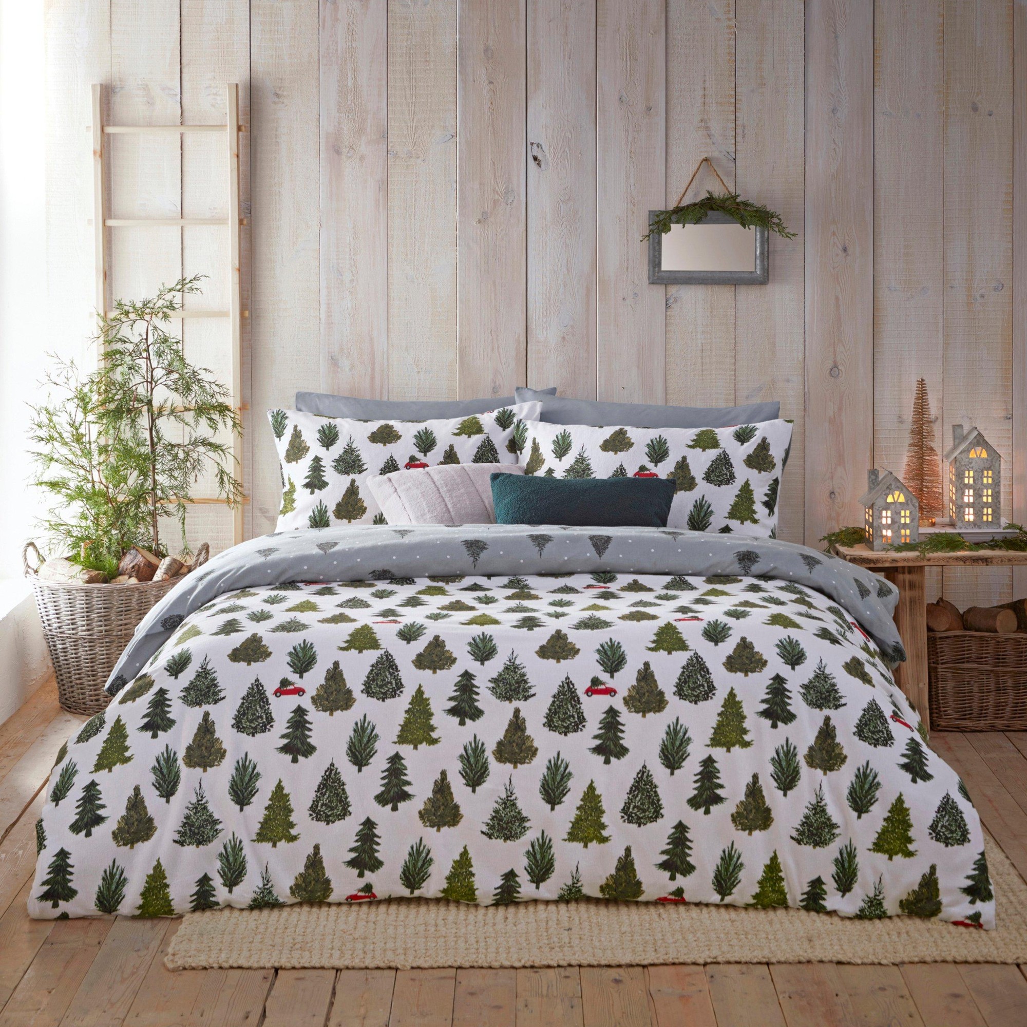 100% brushed cotton super king duvet cover set featuring a forest-themed design with green trees on a white background, complemented by matching pillowcases and a cozy, natural setting.