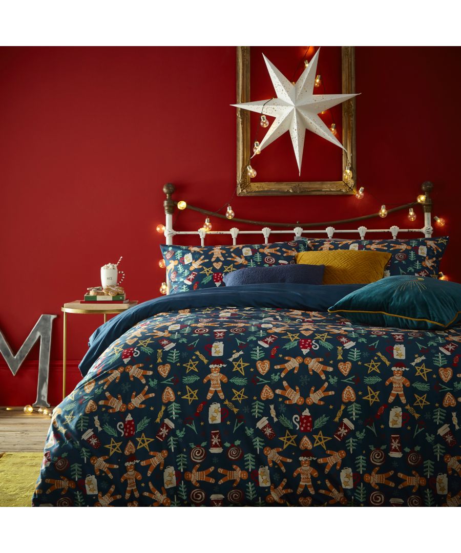 Navy fleece duvet cover set featuring festive gingerbread men, stars, and candy canes, styled with a cozy bed and decorative elements against a red wall.