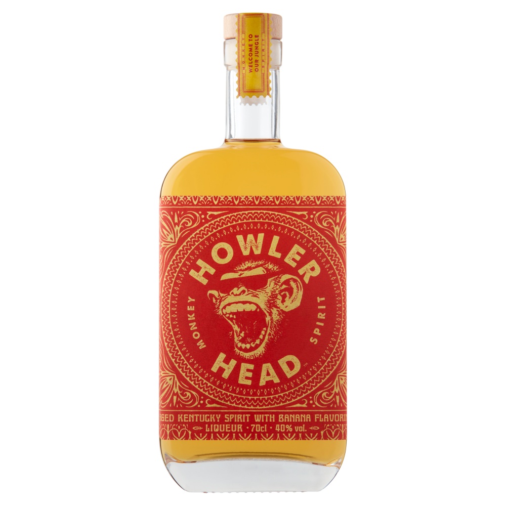 Clear glass bottle of Howler Head Bourbon Liqueur with a vibrant red label featuring a monkey design, filled with golden liquid, and topped with a yellow cap.