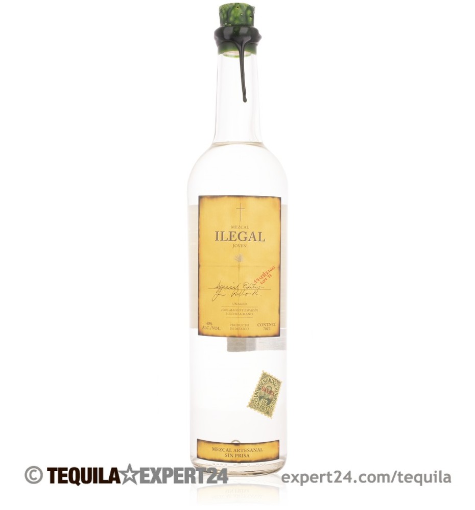 Clear glass bottle of Ilegal Joven Mezcal, 70 Cl, featuring a yellow label with black text, a cork stopper, and a green seal, showcasing an artisanal design.