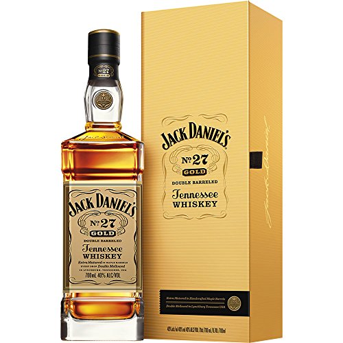 Jack Daniel's No.27 Gold Tennessee Whiskey in a tall, clear glass bottle with a square base, featuring a gold label and a wooden box with gold accents.